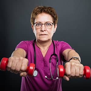 middle-aged, female exercise physiologist holding hand weights
