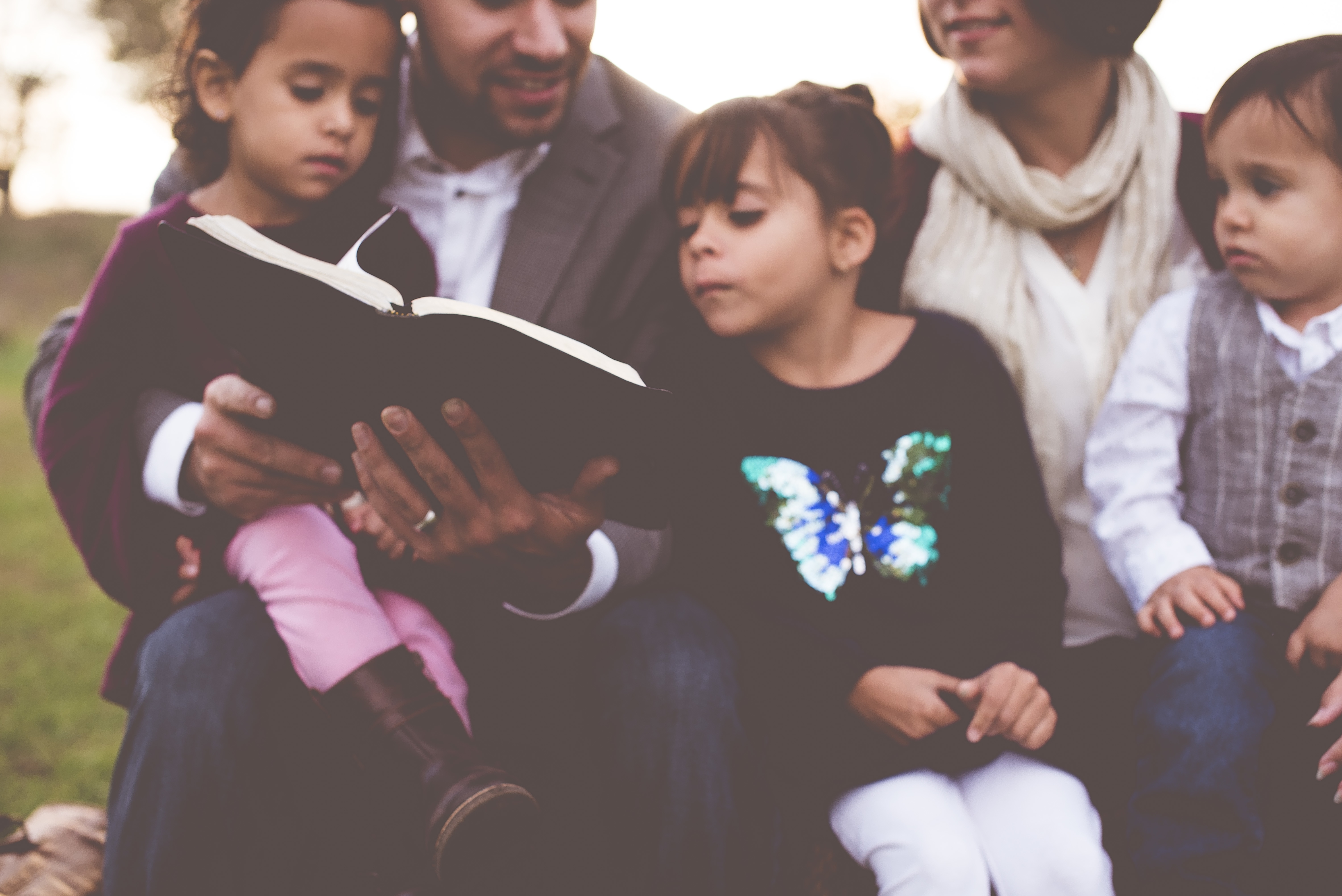 a father reading the bible to his family