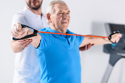 Elderly man using exercise bands