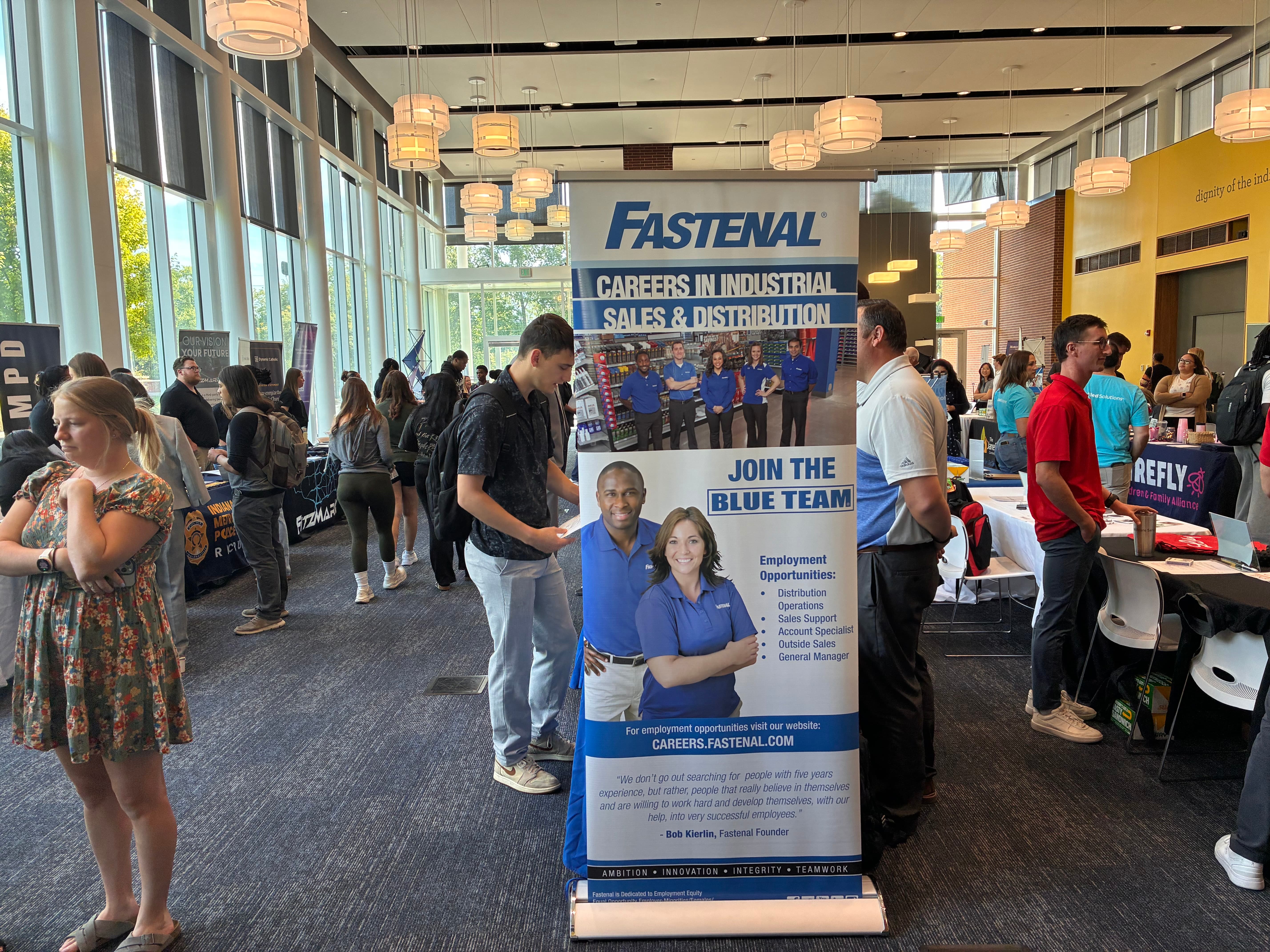 Fastenal recruitment banner showcasing career opportunities in industrial sales and distribution, featuring employees and inviting potential candidates to join the "Blue Team."