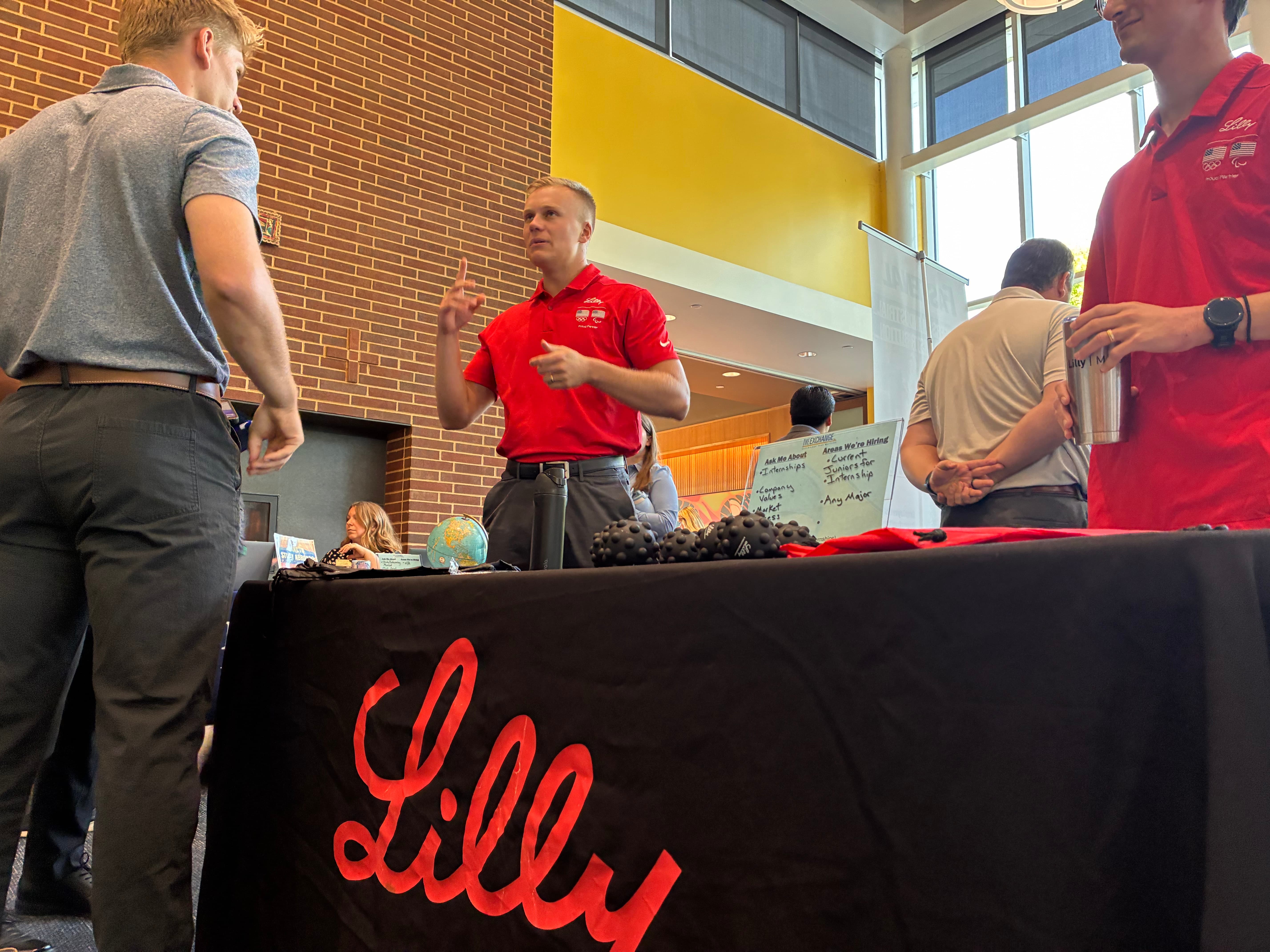 Lilly company representatives engaging with attendees at a career fair.